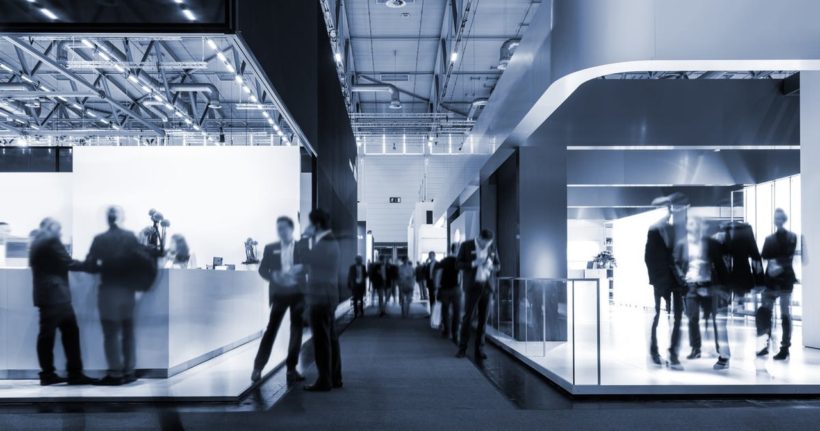 Ticari bir fuarda stand gezen insanlar