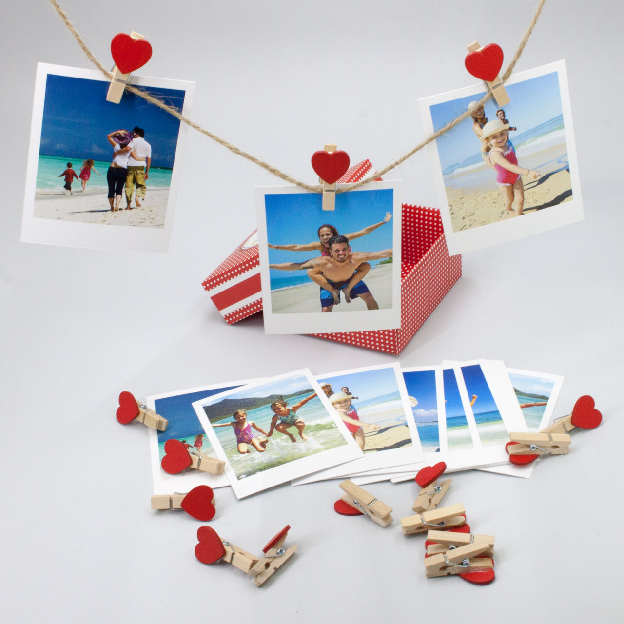 kalpli mandallarla hasır ipe tutturulmuş polaroid fotoğraflar ve hediye kutusu