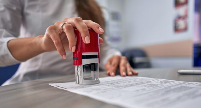 Resmi bir evrağa kaşe basan kadın