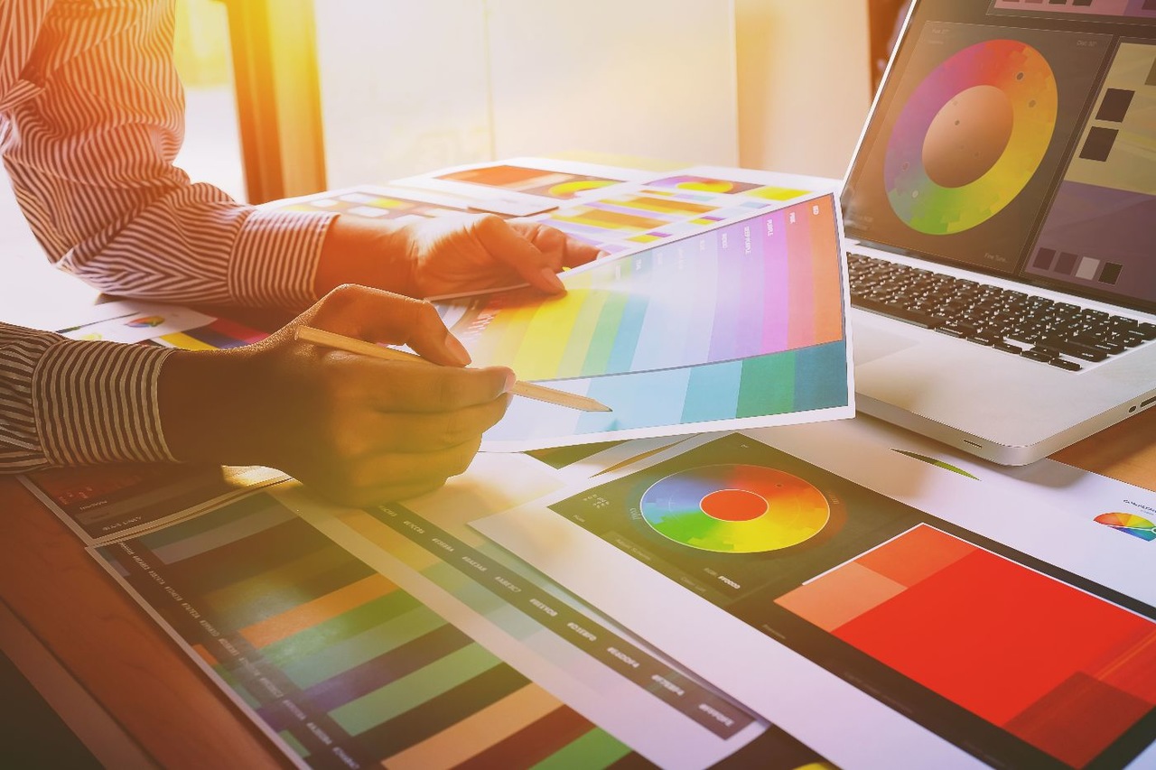 Kağıtlardaki renkler arasından seçim yapmaya çalışan bir tasarımcı