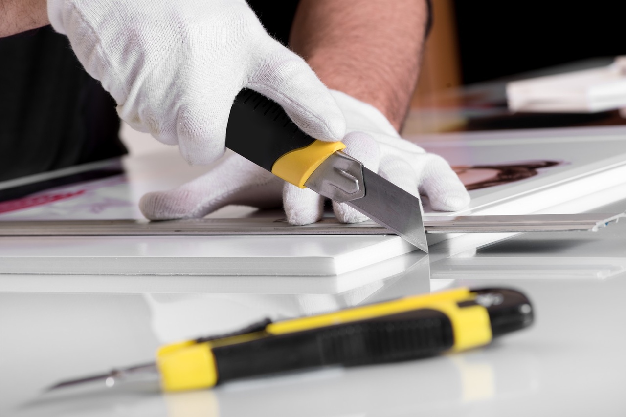 maket bıçağı ile forks baskıyı kesmekte olan eldivenli bir el