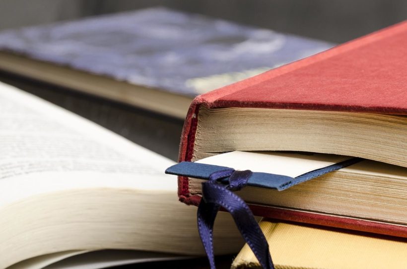 Eski kırmızı bir kitabın arasında konmuş kitap ayracı