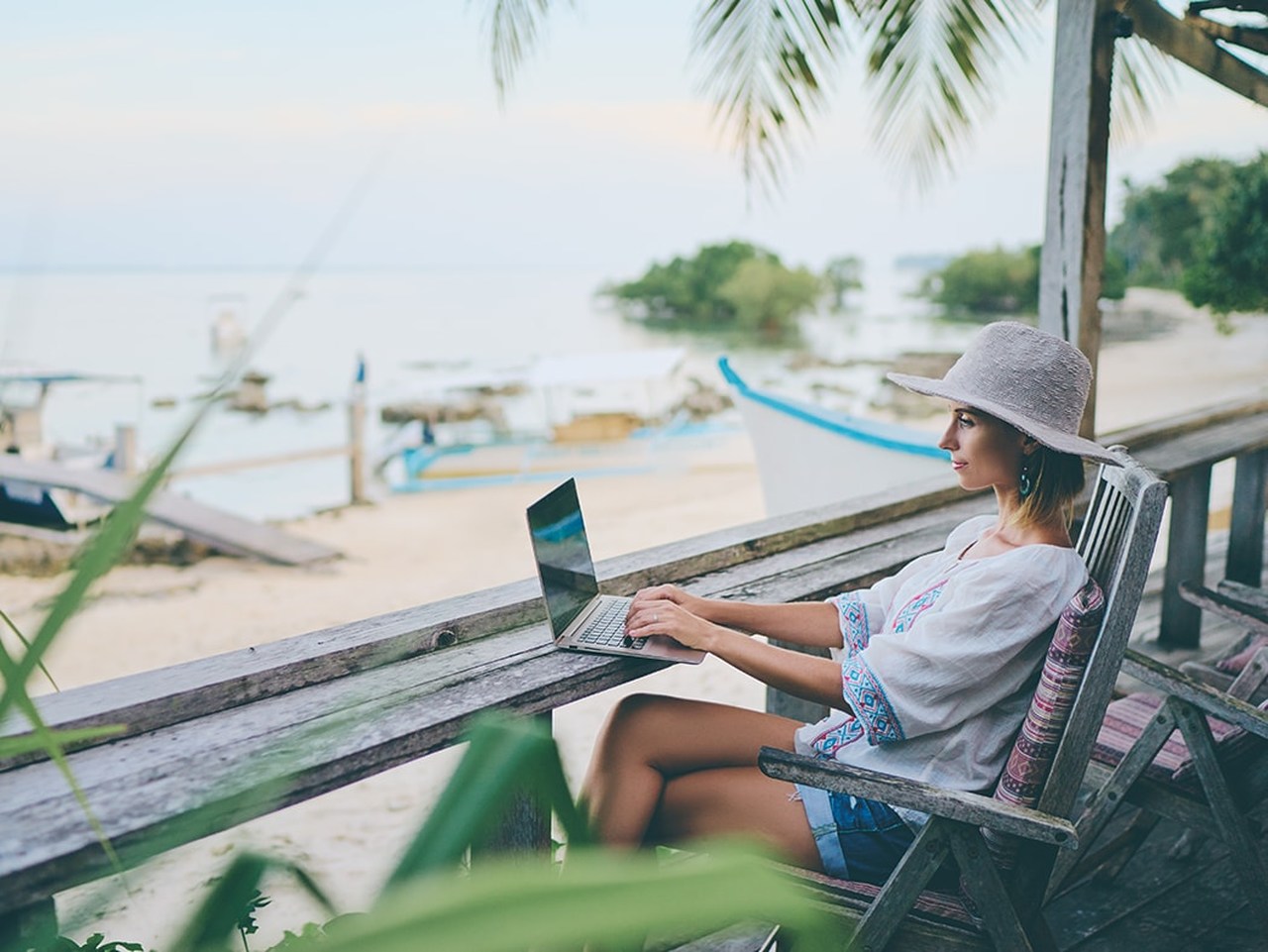 Denize karşı bilgisayarı ile freelance çalışan kadın