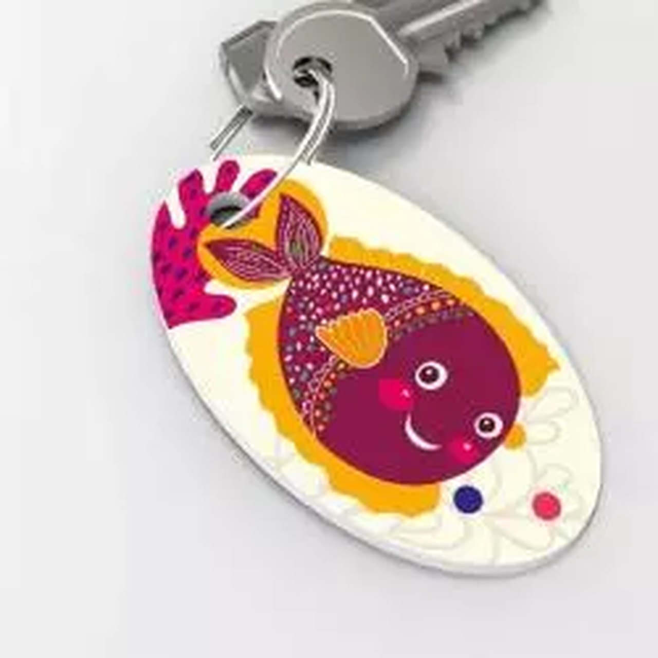üzerinde sarı mor renklerde balık görseli bulunan elips anahtarlık