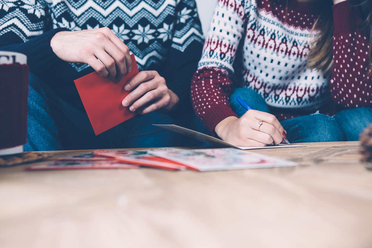 Noel için kartpostal yazan bir aile